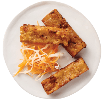 Plate with several golden-brown fried tofu sticks and a small side of shredded carrot and white radish slaw.