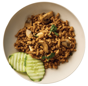 Bowl of ground beef stir-fry with mushrooms and herbs, with cucumber slices on the side.