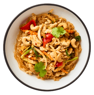 Bowl of chicken stir-fry noodles with carrots, bell peppers, onions, cashews, and cilantro garnish in a white dish.